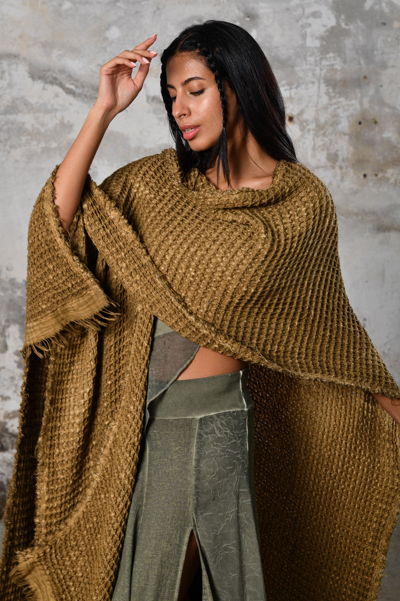 A person wearing the Waffle Poncho, a cozy bohemian-inspired garment made from Turkish cotton, in a serene autumn setting, surrounded by colorful leaves and warm hues, embodying the essence of autumn fashion and comfort.