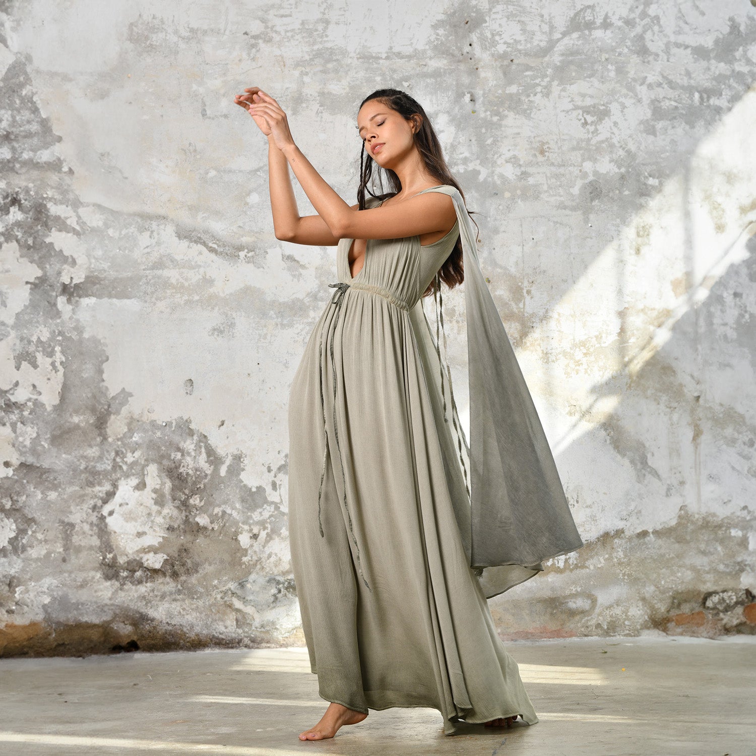 An enchanting Sage Green Greek Goddess Dress, perfect for any occasion. This elegant maxi dress features a flattering open back design, making it an ideal choice for a wedding guest or a bohemian-inspired event. The flowing, ethereal fabric and delicate details embody the essence of a Bohemian Gypsy Maxi Dress, exuding a Boho Sexy Elegant vibe.