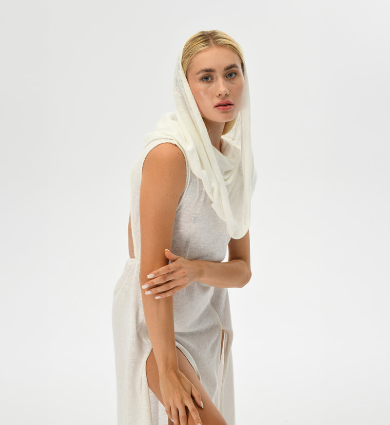 White boho hooded dress with a convertible hood-to-shawl feature, open back, and high side splits. Crafted from hand-dyed cotton and linen, offering natural elasticity for festival and casual wear.