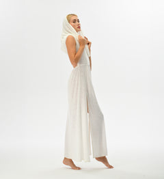 Warrior-inspired white dress with an open back, high side splits, and a hood that transforms into a shawl. Made from a hand-dyed cotton and linen blend, ideal for festival fashion.