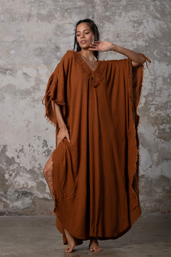 A versatile, earthy goddess dress that embodies boho-chic style. Crafted from the softest cotton fabric, this garment offers both comfort and a fashion statement. The dress can be worn in two distinct styles, either as a kaftan or a sultry dress, with a simple change in the way you put it on. Its natural and ethereal design exudes a warm, comforting feeling against your skin, making it a must-have addition to your wardrobe for those seeking a harmonious blend of style and comfort.