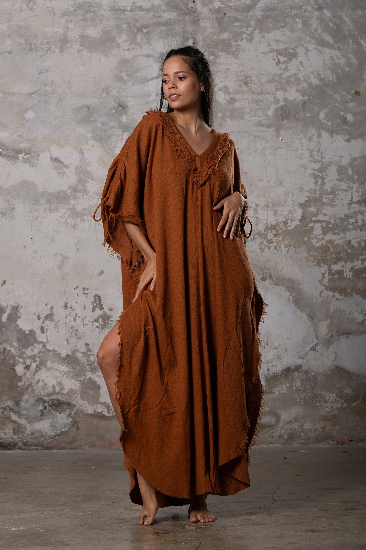 A versatile, earthy goddess dress that embodies boho-chic style. Crafted from the softest cotton fabric, this garment offers both comfort and a fashion statement. The dress can be worn in two distinct styles, either as a kaftan or a sultry dress, with a simple change in the way you put it on. Its natural and ethereal design exudes a warm, comforting feeling against your skin, making it a must-have addition to your wardrobe for those seeking a harmonious blend of style and comfort.
