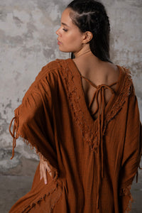 A versatile, earthy goddess dress that embodies boho-chic style. Crafted from the softest cotton fabric, this garment offers both comfort and a fashion statement. The dress can be worn in two distinct styles, either as a kaftan or a sultry dress, with a simple change in the way you put it on. Its natural and ethereal design exudes a warm, comforting feeling against your skin, making it a must-have addition to your wardrobe for those seeking a harmonious blend of style and comfort.