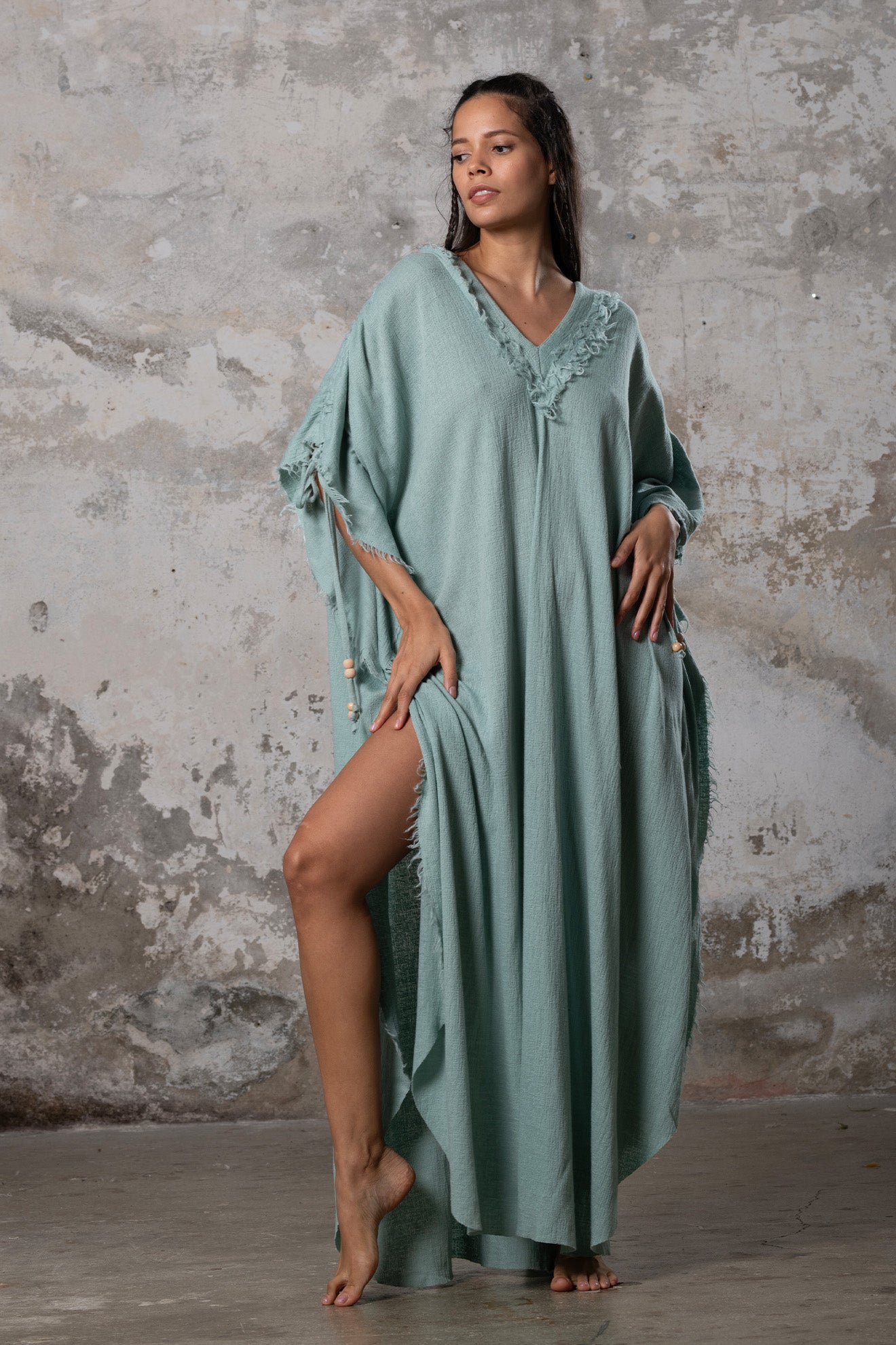 A versatile, earthy goddess dress that embodies boho-chic style. Crafted from the softest cotton fabric, this garment offers both comfort and a fashion statement. The dress can be worn in two distinct styles, either as a kaftan or a sultry dress, with a simple change in the way you put it on. Its natural and ethereal design exudes a warm, comforting feeling against your skin, making it a must-have addition to your wardrobe for those seeking a harmonious blend of style and comfort.