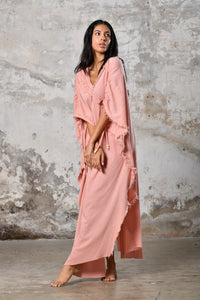 A versatile, pink earthy goddess dress that embodies boho-chic style. Crafted from the softest cotton fabric, this garment offers both comfort and a fashion statement. The dress can be worn in two distinct styles, either as a kaftan or a sultry dress, with a simple change in the way you put it on. Its natural and ethereal design exudes a warm, comforting feeling against your skin, making it a must-have addition to your wardrobe for those seeking a harmonious blend of style and comfort.