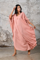 A versatile, pink earthy goddess dress that embodies boho-chic style. Crafted from the softest cotton fabric, this garment offers both comfort and a fashion statement. The dress can be worn in two distinct styles, either as a kaftan or a sultry dress, with a simple change in the way you put it on. Its natural and ethereal design exudes a warm, comforting feeling against your skin, making it a must-have addition to your wardrobe for those seeking a harmonious blend of style and comfort.