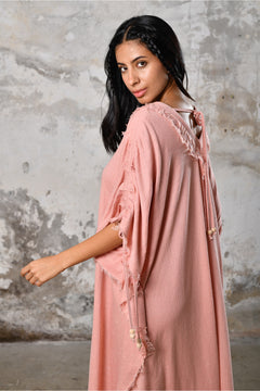 A versatile, pink earthy goddess dress that embodies boho-chic style. Crafted from the softest cotton fabric, this garment offers both comfort and a fashion statement. The dress can be worn in two distinct styles, either as a kaftan or a sultry dress, with a simple change in the way you put it on. Its natural and ethereal design exudes a warm, comforting feeling against your skin, making it a must-have addition to your wardrobe for those seeking a harmonious blend of style and comfort.