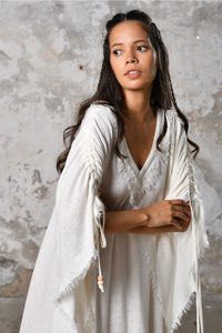 A versatile, White earthy goddess dress that embodies boho-chic style. Crafted from the softest cotton fabric, this garment offers both comfort and a fashion statement. The dress can be worn in two distinct styles, either as a kaftan or a sultry dress, with a simple change in the way you put it on. Its natural and ethereal design exudes a warm, comforting feeling against your skin, making it a must-have addition to your wardrobe for those seeking a harmonious blend of style and comfort.