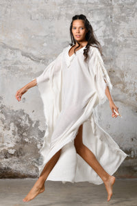 A versatile, White earthy goddess dress that embodies boho-chic style. Crafted from the softest cotton fabric, this garment offers both comfort and a fashion statement. The dress can be worn in two distinct styles, either as a kaftan or a sultry dress, with a simple change in the way you put it on. Its natural and ethereal design exudes a warm, comforting feeling against your skin, making it a must-have addition to your wardrobe for those seeking a harmonious blend of style and comfort.