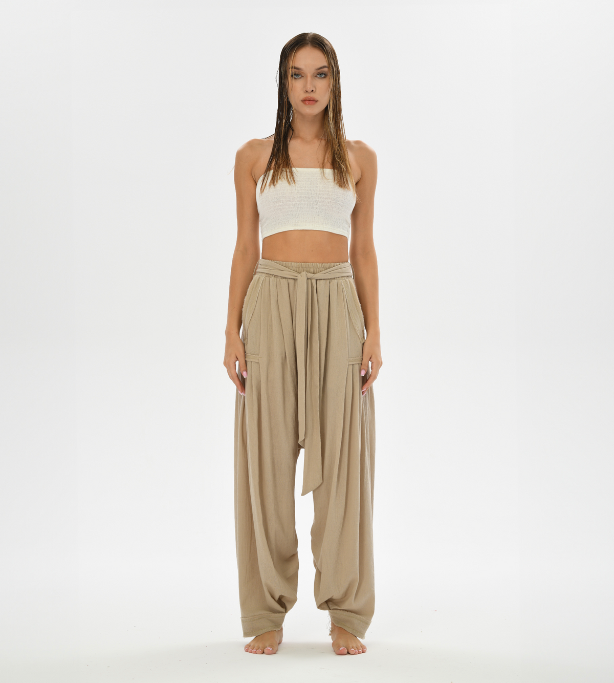 Women’s loose beige pants with a harem style cut, crafted from soft cotton for casual boho chic looks or yoga sessions.