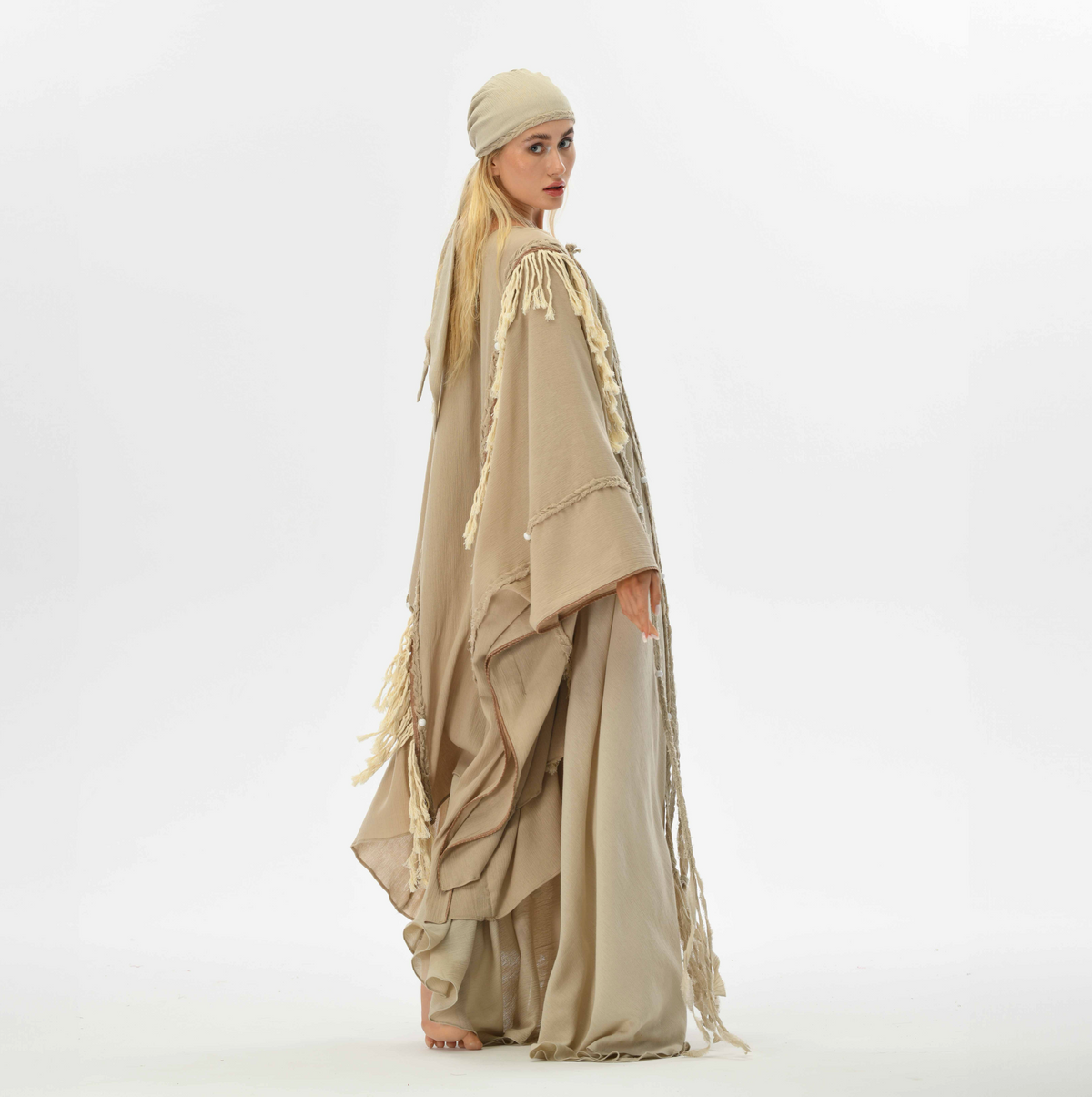 Beige boho cape with fringes and braided details, made from organic cotton, perfect for women’s casual boho chic style.