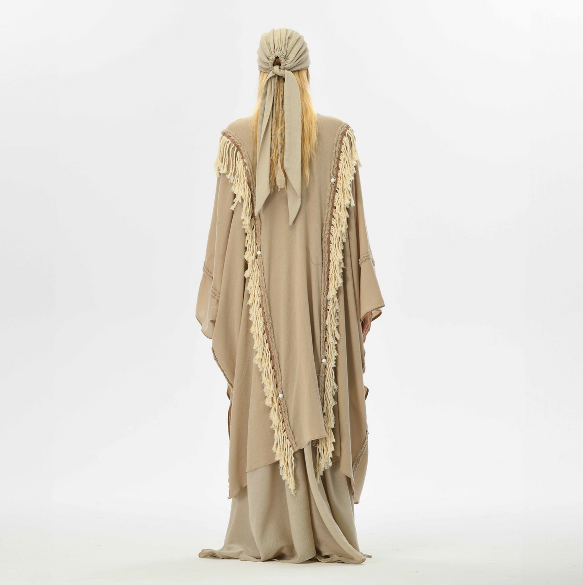 Boho fringe cape in beige, made from organic cotton with handmade tassels and braided details, perfect for casual wear or festival fashion.