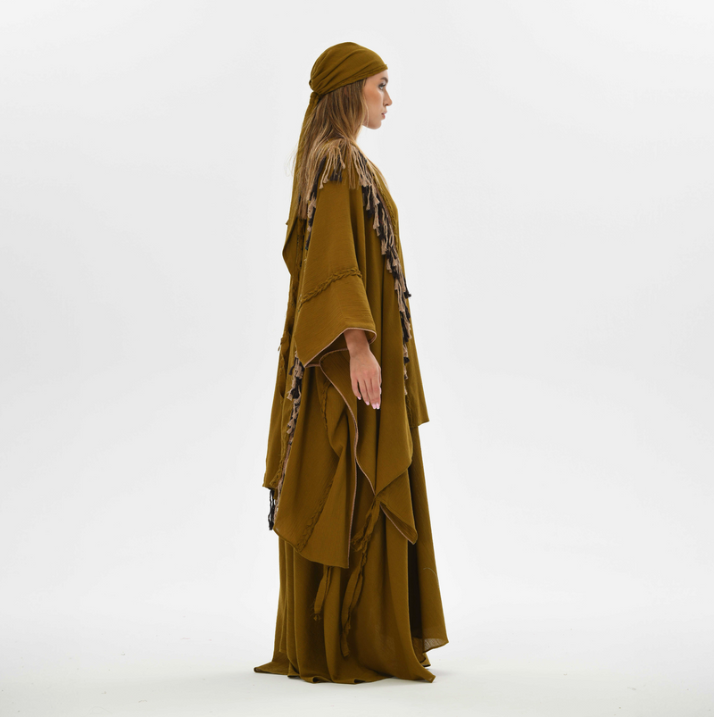 Brown boho poncho for women, crafted from organic cotton with fringe and braided accents, ideal for festival wear or casual bohemian layering.