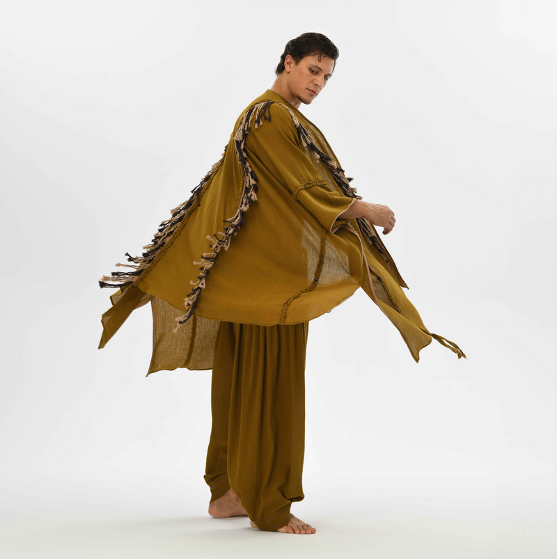 Hand loomed men’s boho poncho in brown, made from organic cotton with tassels and fringe, ideal for tropical cover-ups or shamanic fashion.