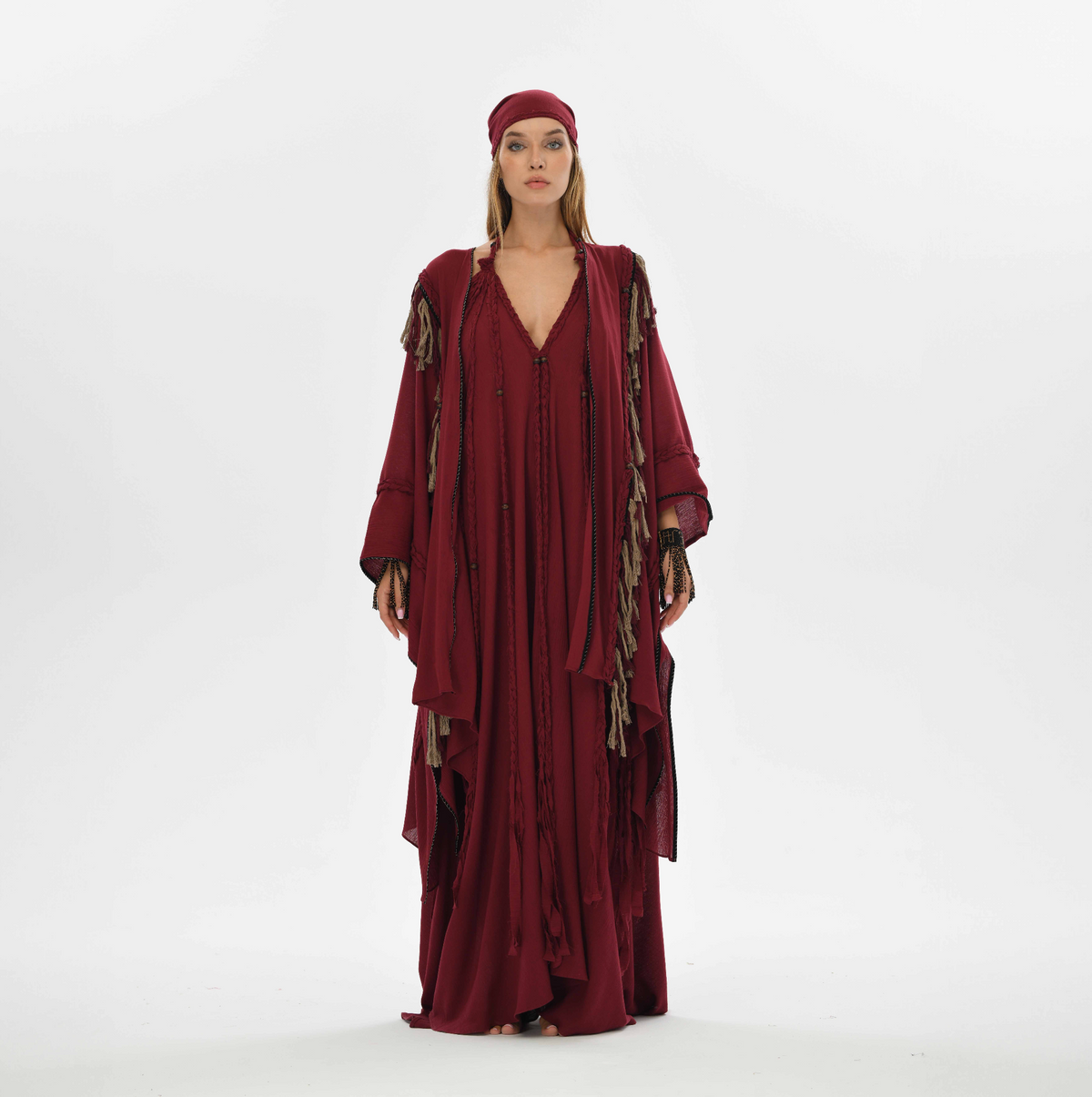 Organic cotton red poncho with braids and fringes, designed for women’s bohemian style. Fits sizes XS to XXL, ideal for casual wear or festival layering.