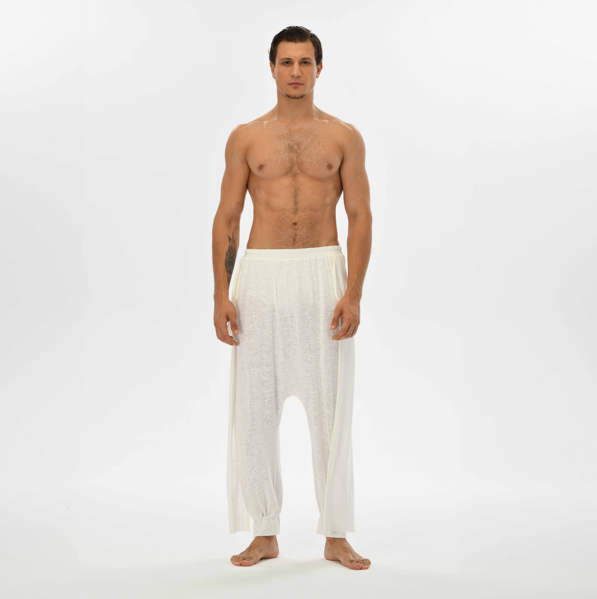 Alchemist-inspired men’s harem pants in white, offering a relaxed fit and breathable fabric, ideal for festivals or lounging.