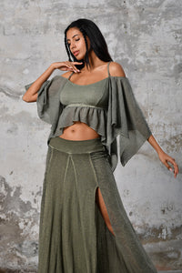 An enchanting Bohemian Venus Green blouse, perfect for boho and festival-inspired looks, exuding a goddess-like quality. The creamy white, flowy fabric and intricate side details create an ethereal, bohemian style perfect for Burning Man and other occasions. This garment is an ethically crafted gem
