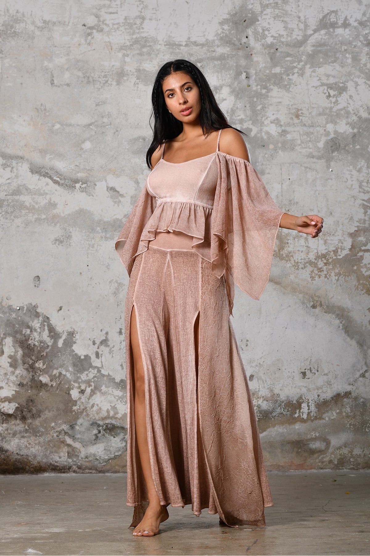 An enchanting Bohemian Venus Powder pink blouse, perfect for boho and festival-inspired looks, exuding a goddess-like quality. The creamy white, flowy fabric and intricate side details create an ethereal, bohemian style perfect for Burning Man and other occasions. This garment is an ethically crafted gem