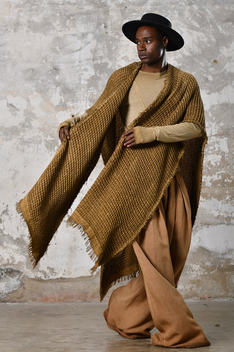 A person wearing the Waffle Poncho, a cozy bohemian-inspired garment made from Turkish cotton, in a serene autumn setting, surrounded by colorful leaves and warm hues, embodying the essence of autumn fashion and comfort.